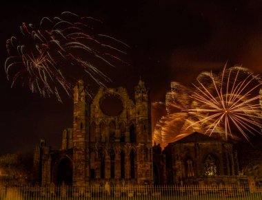 Fireworks in the dark sky over Elgin Cathedral on bonfire night clipart