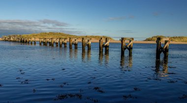 Suyun üzerindeki köprüden sahile kadar eski ahşap destekler.