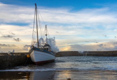 Fırtına sırasında İskoçya 'nın Morayshire kıyısında büyük dalgalar bir liman duvarını yıkıyor.