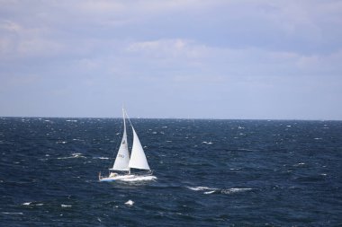 Bornholm 'ün doğu yakasındaki Baltık Denizi' nde dalgalı denizde yelkenli.