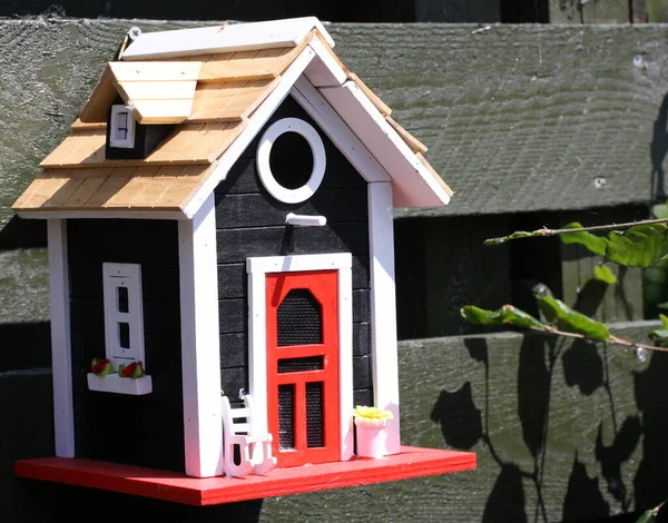 stock image Feeding house for small birds looking like a smalle cottage with a rocking chair