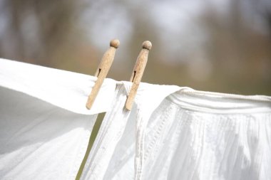 Rüzgarlı havada çamaşır ipinde eski moda çamaşırlar. Parkta tahta kıskaçlar var.