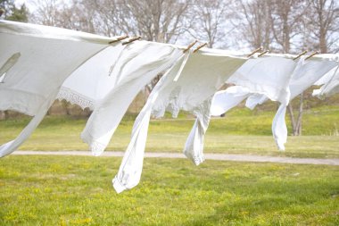 Rüzgarlı havada çamaşır ipinde eski moda çamaşırlar. Parkta tahta kıskaçlar var.