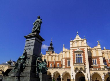 Ön planda Adam Mickiewicz Anıtı ve arka planda Kuaför salonu olan Pazar Meydanı manzarası. Krakow, Polonya 'da