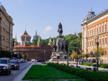 Krakow, Polonya - 12 Ağustos 2022: Plac Jana Matejki 'deki Krakow Barbican ve Grunwald Anıtı (İngilizce: Jan Matejko Square).
