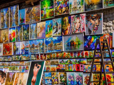 Krakow, Polonya - 12 Ağustos 2022: Eski kasabadaki Florian 's Gate' in önünde resimlerini satan sokak sanatçısı.