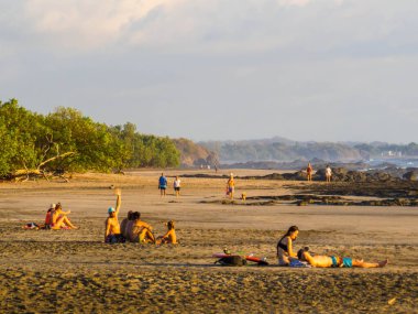 Tamarindo, Kosta Rika - 6 Şubat 2024: Playa Negra 'da insanlar gün batımında.