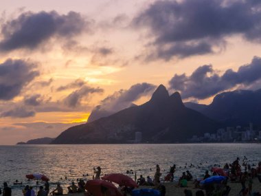İki Kardeşler Tepesi ve Vidigal gecekondu mahallesi gün batımında Ipanema Sahili 'nde görülüyor. Rio de Janeiro, Brezilya 'da
