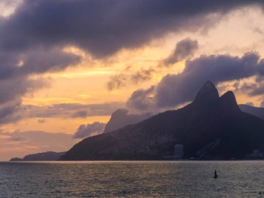 İki Kardeşler Tepesi ve Vidigal gecekondu mahallesi gün batımında Ipanema Sahili 'nde görülüyor. Rio de Janeiro, Brezilya 'da