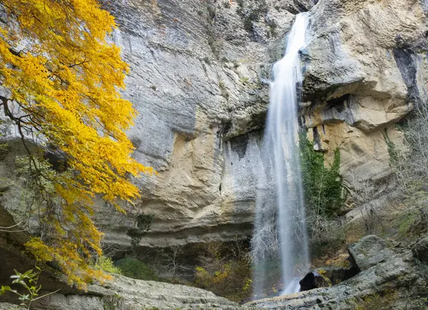 Waterfall next to a tree with autumn colors in Artazul, Ollo valley, Navarra, Spain
