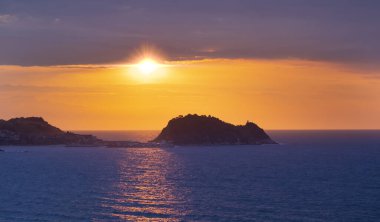 Günbatımı güneşi denizin üzerinde ve Getaria kıyılarında, Euskadi