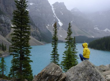 Moraine Gölü 'nün yanında oturan kadın, Banff Ulusal Parkı, Kanada