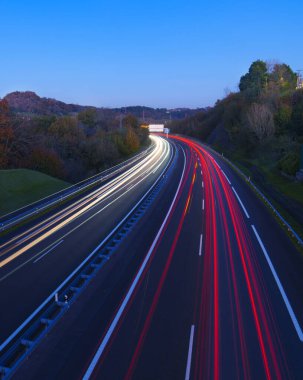 AP-1 highway. Car lights at dusk on the AP-1 highway as it passes through Hernani, Euskadi. clipart