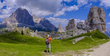İtalyan Dolomitlerinde Cinque Torri 'nin fotoğrafını çeken yürüyüşçü