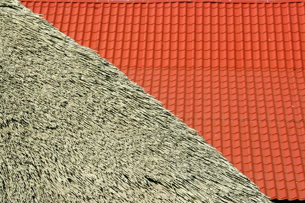 Kırmızı fayansların soyut geometrik dokusu ve arka plandaki sazdan çatı.