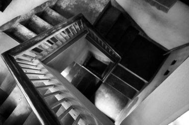 Yukarıdan görülen klasik sarmal merdivenlerin siyah ve beyaz bir fotoğrafı geometrik simetrisini ve zamansız estetiğini gözler önüne seriyor. Işık ve gölgelerin etkileşimi, yapısal sanatın gelişimini sağlar..