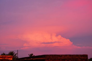 Alacakaranlığa karışan tüylü bulutlarla dolu pembe akşam gökyüzü huzurlu ve huzurlu bir ortam sunuyor. Gökyüzünün güzelliğini gösteren doğa ve manzara fotoğrafçılığı için ideal..
