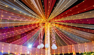 Renkli ışıklar ve süslemelerle süslenmiş şenlikli tavan, kutlamalara uygun canlı bir ortam yaratıyor. Işığın ve kumaşın etkileşimi neşeli ve davetkar bir ruh hali yaratır..