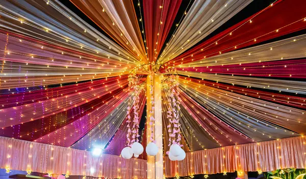 Renkli ışıklar ve süslemelerle süslenmiş şenlikli tavan, kutlamalara uygun canlı bir ortam yaratıyor. Işığın ve kumaşın etkileşimi neşeli ve davetkar bir ruh hali yaratır..