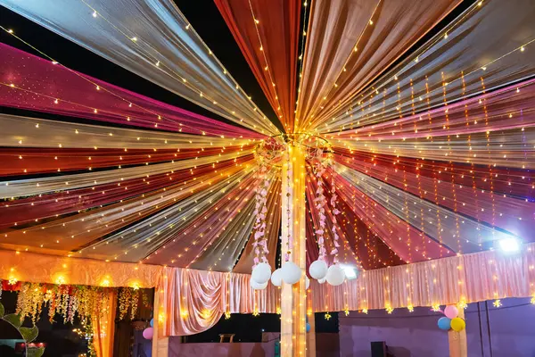 Renkli ışıklar ve süslemelerle süslenmiş şenlikli tavan, kutlamalara uygun canlı bir ortam yaratıyor. Işığın ve kumaşın etkileşimi neşeli ve davetkar bir ruh hali yaratır..