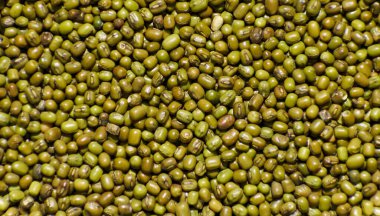 Yeşil mung fasulyelerinin yoğun bir diziliminin detaylı bir yakın çekimi. Yeşil gram olarak da bilinir. Dokularını ve doğal renklerini gözler önüne serer..