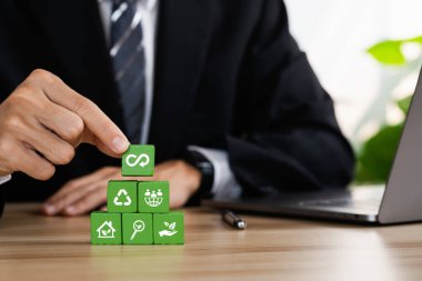 Dairesel ekonomi konsepti. İş ve çevre sürdürülebilir. İklim değişikliği problem çözme hedefleri. Kirlilik kaynakları simgesine sürdürülebilirlik simgesi içeren tahta küplerin gri arkaplan ile istiflenmesi