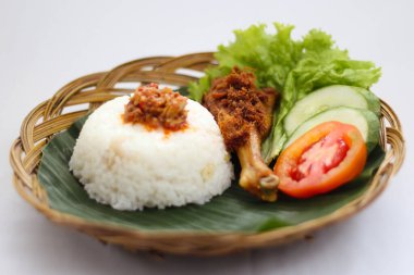 Pilav tabağı ve tavuk budu olan bir tabak yemek.