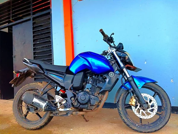 stock image Atambua, East Nusa Tenggara - 23 March 2023: A Motorcycle parking on the road left side ready to ride