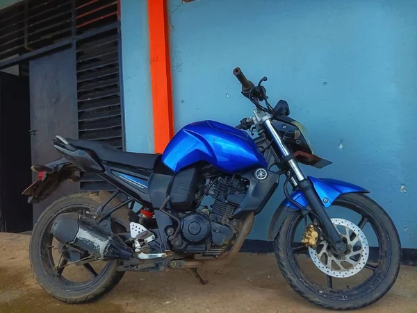 Atambua, Doğu Nusa Tenggara - 23 Mart 2023: Yolun sol tarafında motosiklet parkı