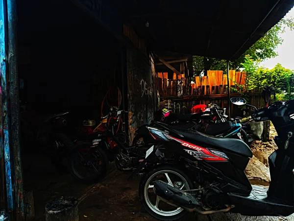 Atambua, Doğu Nusa Tenggara - 7 Nisan 2023: Motosiklet tamirhanesinde birkaç motosiklet tamircisi tarafından bakım yapılıyor