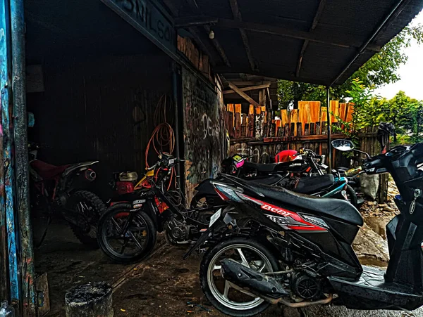 Atambua, Doğu Nusa Tenggara - 7 Nisan 2023: Motosiklet tamirhanesinde birkaç motosiklet tamircisi tarafından bakım yapılıyor