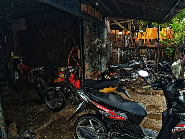 Atambua, Doğu Nusa Tenggara - 7 Nisan 2023: Motosiklet tamirhanesinde birkaç motosiklet tamircisi tarafından bakım yapılıyor