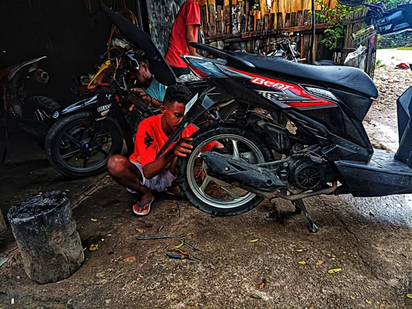 Atambua, Doğu Nusa Tenggara - 7 Nisan 2023: Motosiklet tamirhanesinde birkaç motosiklet tamircisi tarafından bakım yapılıyor