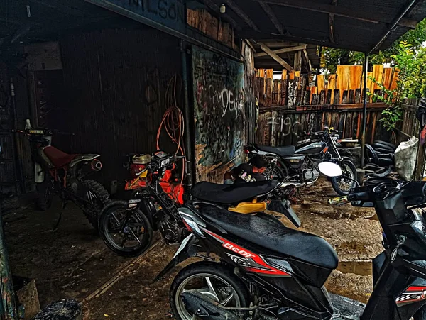 Atambua, Doğu Nusa Tenggara - 7 Nisan 2023: Motosiklet tamirhanesinde birkaç motosiklet tamircisi tarafından bakım yapılıyor