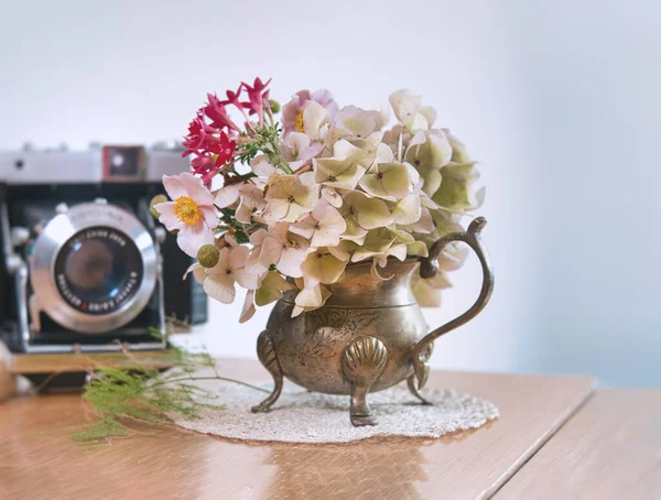 vintage camera with flowers and a bouquet of pink roses
