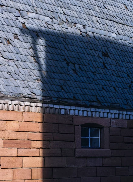 砖墙的屋顶 旧楼墙壁上的轻影游戏 — 图库照片