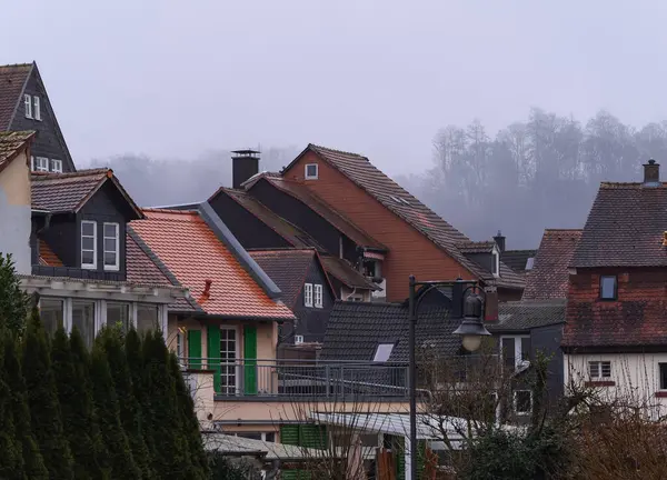 View in rain and fog over roofs in Weidenhausen,