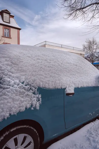Winter, some snow in the city, Snow on car roof with sun