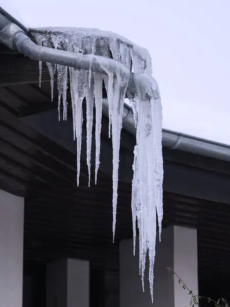 a roof with icicles hanging off of it, Long icicles hanging on roof