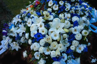 Çiçek çelengi, mezarlıkta yas tutmak için renkli çiçekler, unutulmaz çiçekler, çiçek bokeh, anılar.,