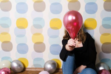 Genç Kadın Uzatıyor, Yüzünü Gri Arkaplanla Kaplayan Pembe Balon Veriyor