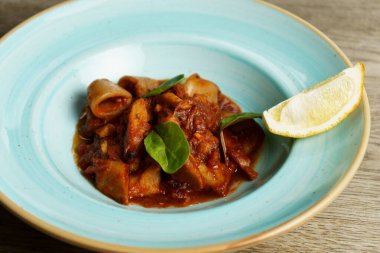 Baharatlı domates soslu ve limonlu kalamar.