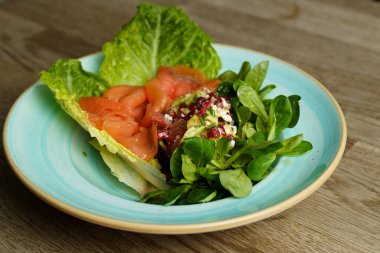 Somon füme salata ve ahşap bir masada Avokado bir tabak