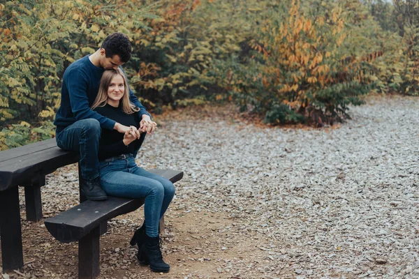 一对快乐的年轻夫妇坐在公园的长椅上 — 图库照片