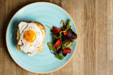 Peynirli ve jambonlu klasik Fransız tostu, kızarmış yumurta, sebze ve ballı sos..