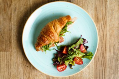 Jambon, sebze ve peynirli kruvasan manzarası.