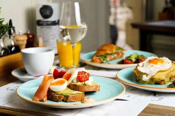 Avokado tostlu brunch masası guacamole, kaynamış yumurta, somon, krem peynir ve domatesli.