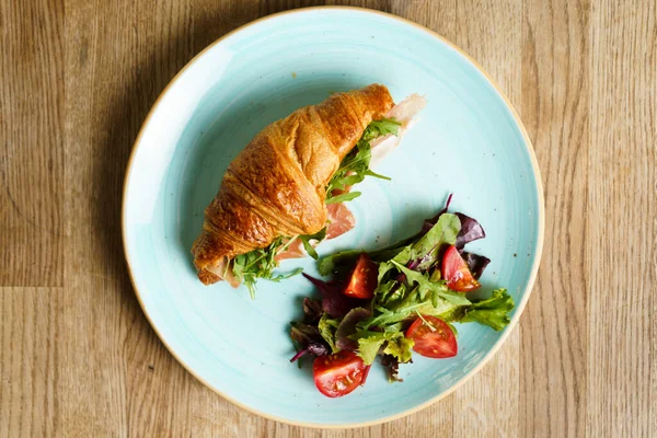 Jambon, sebze ve peynirli kruvasan manzarası.