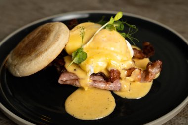 Benedict usulü yumurta, domuz pastırması ve jambon.