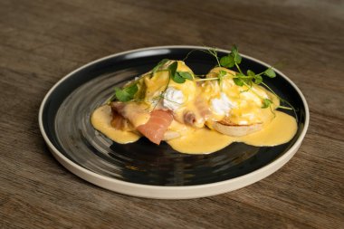 Tahta bir masada somonlu Benedict yumurtası.